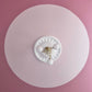 a photo of floral plaster ceiling rose with pink highlights and contemporary lighting fixture. 